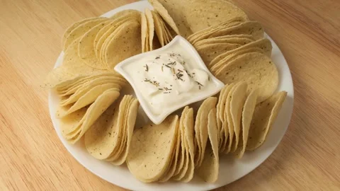 Corn tortilla chips with dip rotating on a wooden table Stock Footage 344915156