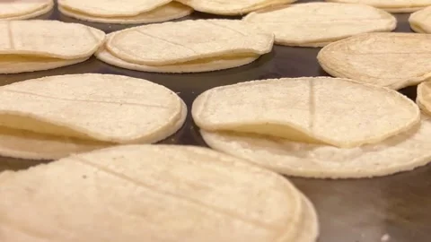 Corn tortillas on a flat griddle cooking, close-up shot, showcasing a golden Stock Footage 295028619