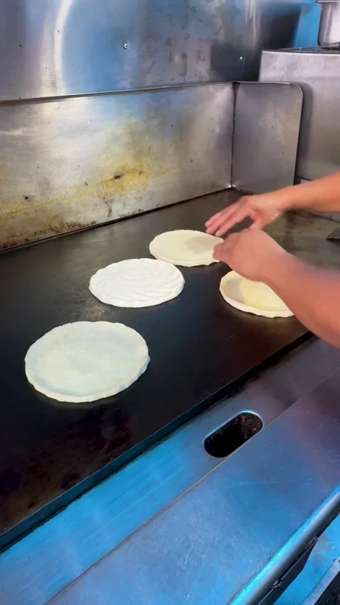 Corn tortillas warming on flat top grill in taco truck kitchen 库存影片 330269828