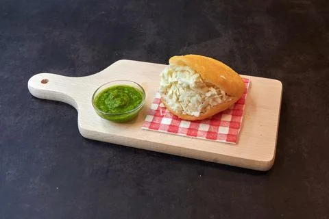 A cornbread with cheese and a green sauce Stock Photos