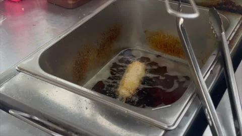Corndog being deep fried in hot oil 스톡 동영상 336453962