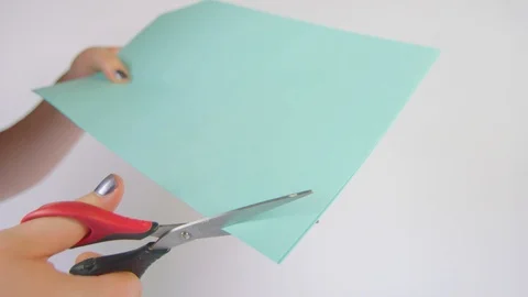 Corner being cut off a blue piece of paper Stock Footage 85363868