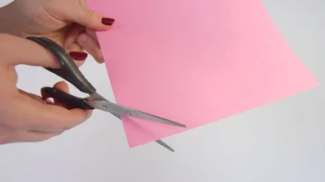 A corner being cut off pink paper Stockbeeldmateriaal 85363219