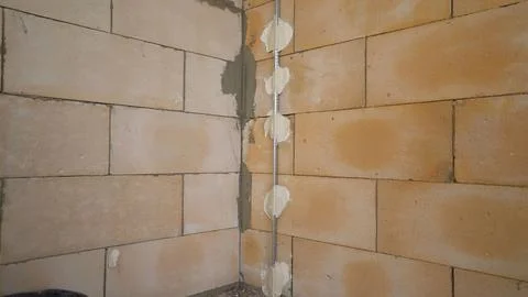 Corner of a block wall during house construction with plaster guides. Stock Photos