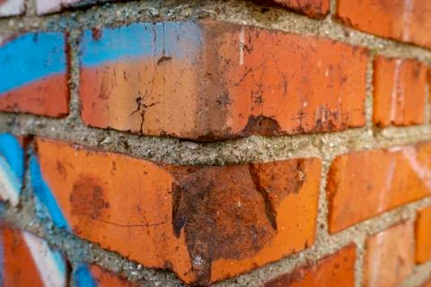 Corner of brick wall with graffiti in close-up Stock Photos