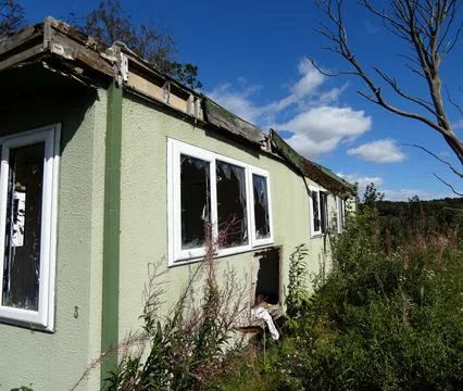 The corner of broken window on a pale green mobile home Stock Photos