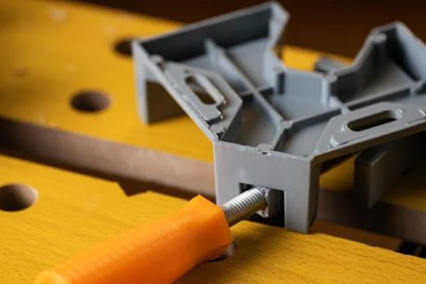 Corner clamp fixed on wooden workbench top in carpentry workshop Stock Photos