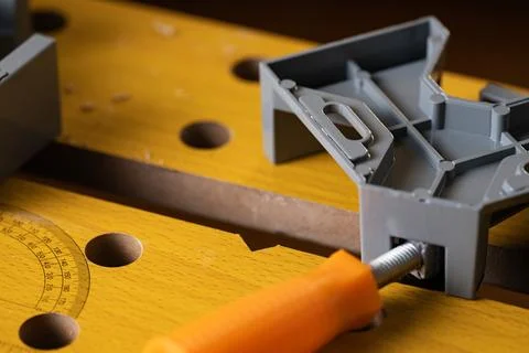 Corner clamp fixed on wooden workbench top in carpentry workshop Stock Photos