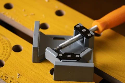 Corner clamp fixed on wooden workbench top in carpentry workshop Stock Photos