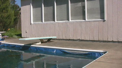 Corner of closed pool with diving board and shed Stock Footage 545013