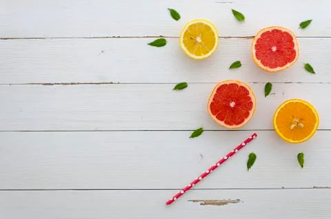 Corner composition with arranged cut lemon, grapefruit, straw and mint leafs on Stock Photos