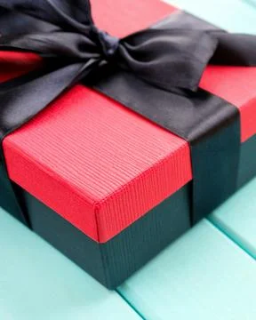 A corner of a gift box with a black bow. Vertical photo Stock Photos