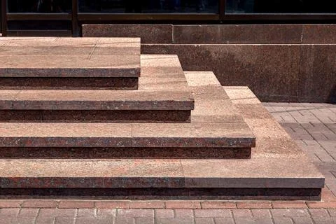 A corner granite staircase with stone steps rise to the entrance. Stock Photos