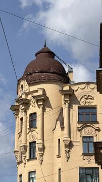 Corner of a historic beige building featuring a brown dome roof, tall windows Stock Photos