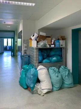 In a corner of a hospital corridor different garbage bags are piled up Stock Photos