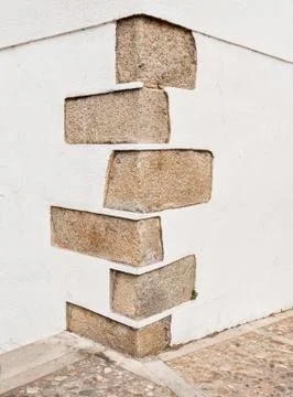The corner of an old building where the construction is reinforced with granite Stock Photos