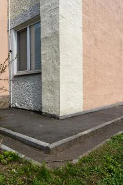 Corner of an old house with a window and asphalt old architecture of a Stock Photos