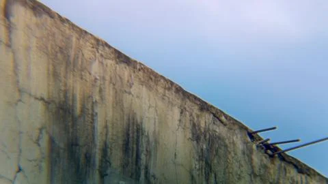 Corner of an old wall with sky and white clouds in the background. Stock Photos