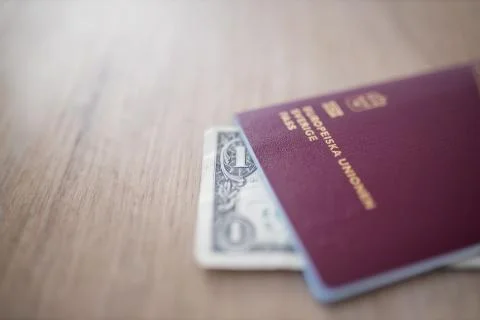 The Corner of a One-Dollar Bill Shown Outside a Sweden Passport Stock Photos