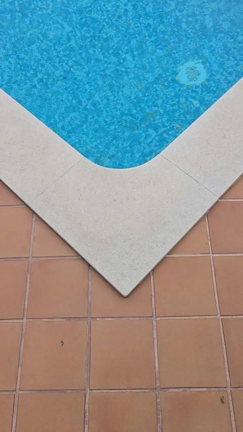 Corner of a private home swimming pool with blue water and orange tiles Stock Footage 346726419