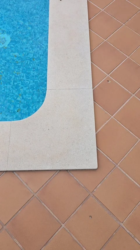 Corner of a private home swimming pool with blue water and orange tiles Stock Footage 346726435