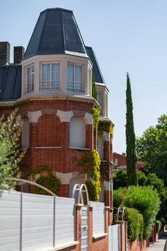 Corner of red brick residence with projecting dormer windows mansard roof a.. Stock Photos