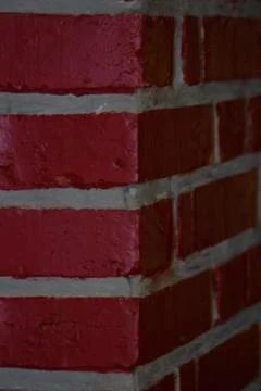 Corner of a red brick wall jointed with gray grout. Stock Photos