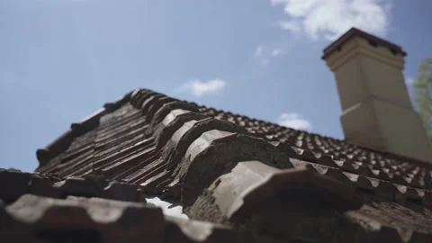 Corner of roof made of old ceramic tiles with ventilation pipe against sky. Stock Footage 239462342