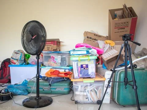 In the corner of the room there is a pile of containers containing books. There  Stock Photos