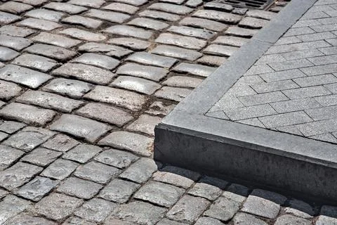 The corner of the sidewalk made of stone tiles. Stock Photos