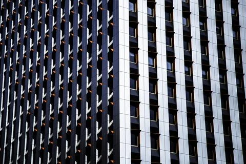 The corner of a skyscraper with small orange overhangs over its windows Fotos Stock