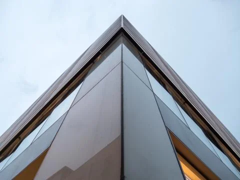 Corner of a skyscraper under a cloudy and cold sky scene from the bottom Stock Photos