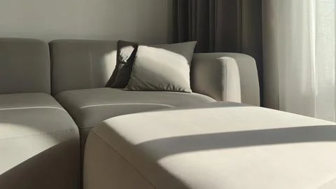 Corner sofa with cushions in modern interior illuminated by sunlight. Soft Stockfoto's