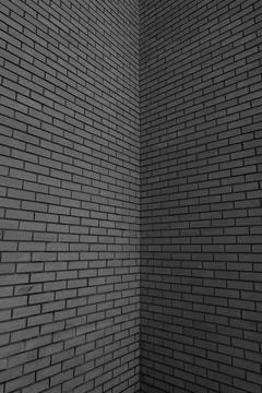 Corner of tall brick wall background texture black and white Stock Photos