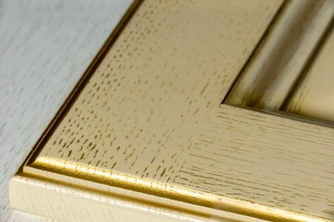Corner of a textured white classic kitchen facade with gilding and texture cl Stock Photos