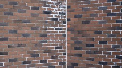 Corner of two brick walls made of dark brown blocks Stock Photos