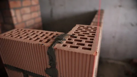 Corner wall construction with red clay blocks and mortar line Stock Footage 311881248