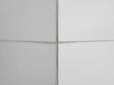 The corner of the wall is lined with white glossy ceramic tiles Stock-Fotos