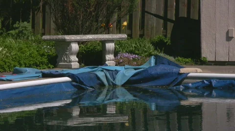 Corner of winterized pool with tarp and stone bench Stock Footage 544916
