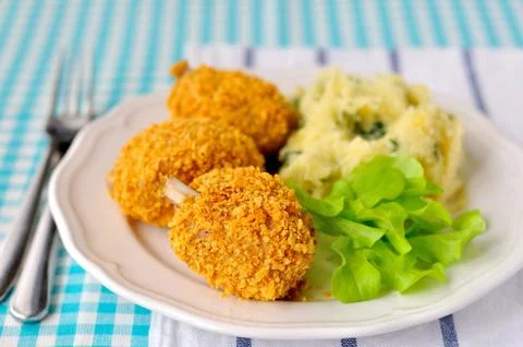 Cornflake crusted chicken pieces served with salad leaves and mashed potatoes Stock Photos