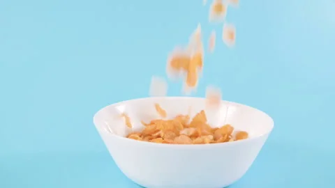 Cornflakes. Dry breakfasts are poured into a bowl. Vitamin food for children and Stock Footage 194132078