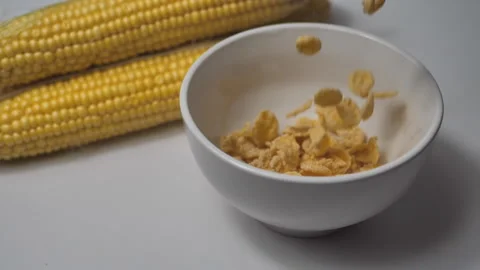 Cornflakes fall into a bowl. corn cobs lie nearby. Stock Footage 159165167