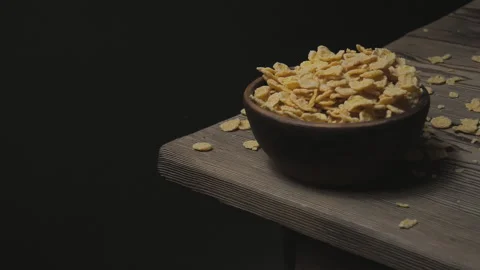 Cornflakes fall into a bowl on a wooden table. Stock Footage 159124942