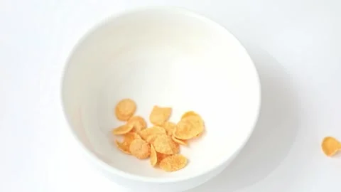 Cornflakes fall into a white cup on a light background Video stock 195152077
