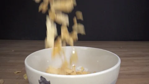 Cornflakes falling from above in a white bown while camera sliding Stock Footage 124015562