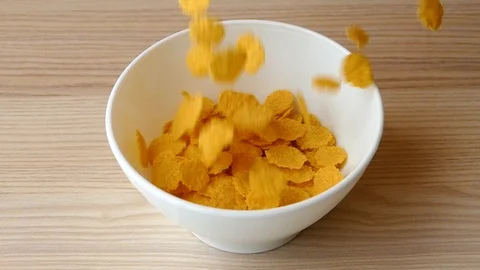Cornflakes falling into white bowl, slow motion Stock Footage 96975866