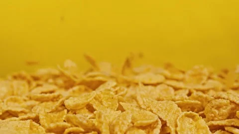 Cornflakes topple on yellow background Stock Footage 143247320