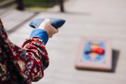 Cornhole game set, process of throwing bean bags, female girl tossing bean .. Stock Photos