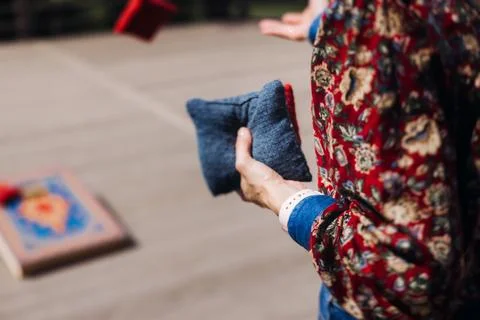 Cornhole game set, process of throwing bean bags, female girl tossing bean .. Stock Photos