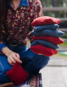 Cornhole game set, process of throwing bean bags, female girl tossing bean .. Фото